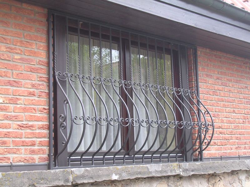 Kunstvoll geschmiedetes Fenstergitter der Firma Karl Ehlers an einer Klinkerfassade